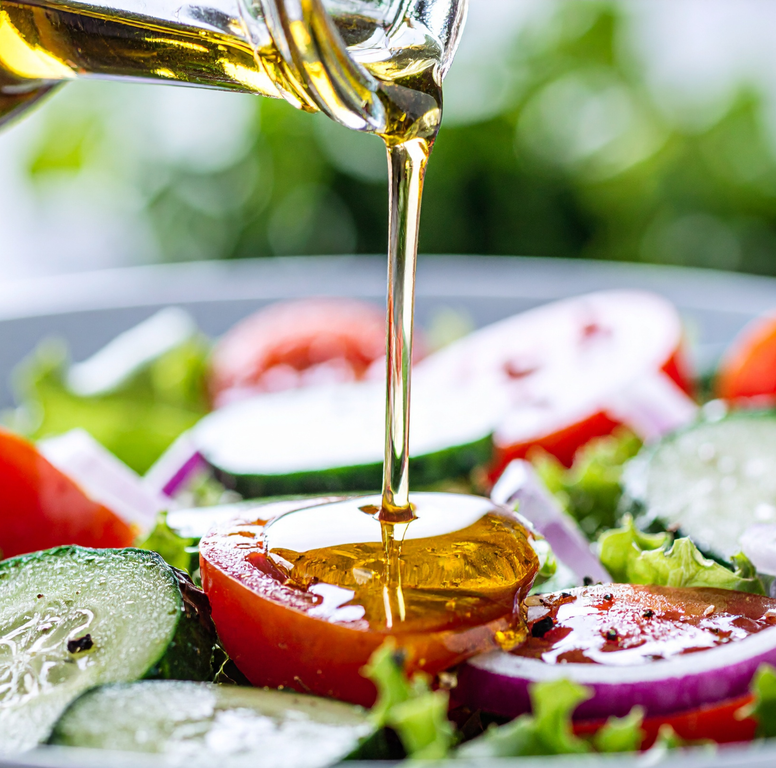 Extra virgin olive oil drizzled over a tomato and cucumber salad