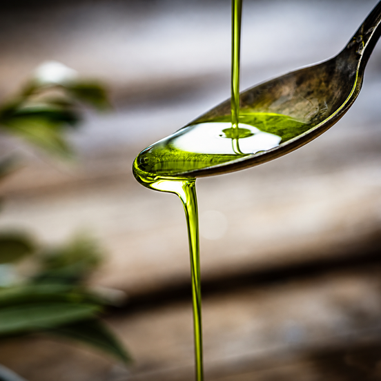 Bright green extra virgin olive oil on a tasting spoon